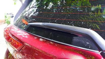 Close up of rear wiper in red car. Car rear window with anti fog. Outdoors. photo