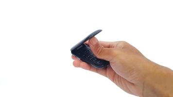 Hand holding obsolete flip cell phone isolated on white background. The old type. photo