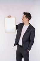 Portrait of happy businessman showing blank signboard on isolated white background photo