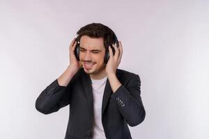 retrato de un joven feliz usando auriculares y disfrutando de la música sobre fondo blanco foto