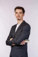 Portrait of young handsome businessman wearing suit standing with crossed arms with isolated on studio white background photo