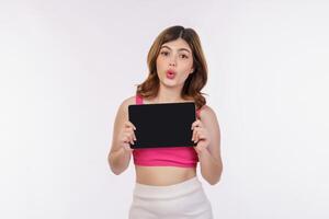 Portrait of excited young woman holding tablet mock up isolated over white background photo