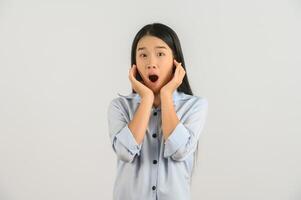 Portrait of Excited young asian woman in blue shirt looking at camera isolated on white background photo