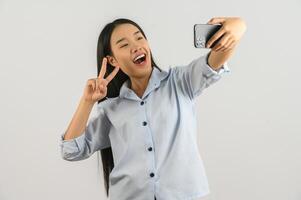 Portrait of Young asian woman expressing surprise while using mobile phone isolated over white background photo