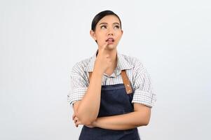 Portrait of thoughtful young asian woman in waitress costume ingenious poseture photo