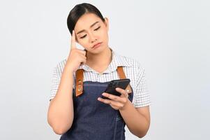 Portrait of young asian woman in waitress uniform pose with smartphone photo