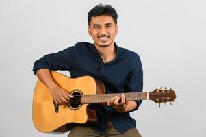 Portrait of Young Asian man playing an acoustic guitar isolated on white background photo