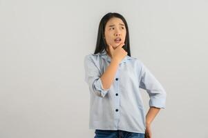 Portrait of Young asian woman in blue shirt thinking and looking up isolated on white background photo