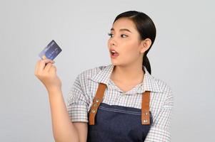 Portrait of young asian woman in waitress uniform pose with credit card