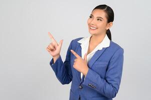 Young beautiful woman in formal clothing for officer point finger posture photo
