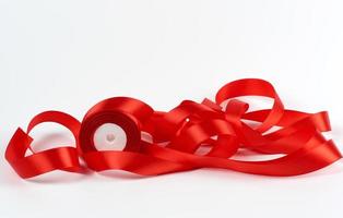 curled red satin ribbon on white background, festive backdrop photo