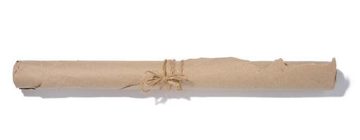 Twisted brown wrapping paper in a roll and tied with a rope on a white background photo