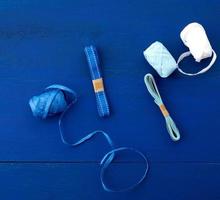 set of different skeins of ribbons for gift wrapping on a blue wooden background photo