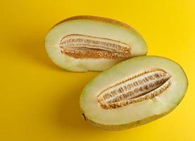 piece of ripe melon with seeds on a yellow background photo