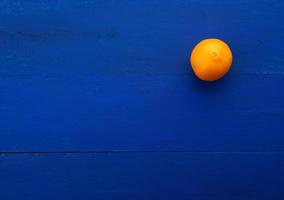 whole orange round orange on a dark blue background from boards photo