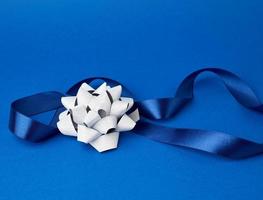 blue silk thin ribbon twisted on a blue background photo