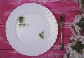 Empty white ceramic plate with empty small piece of paper photo