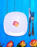 empty white square plate and metal knife and fork photo