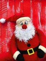 Papá Noel feliz sobre un fondo de madera roja foto