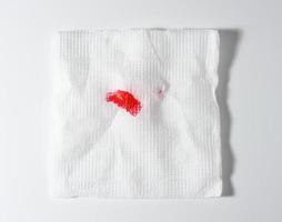 servilleta de papel blanco doblada con lápiz labial rojo sobre fondo blanco foto
