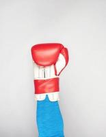 man's hand is wearing a red leather boxing glove photo