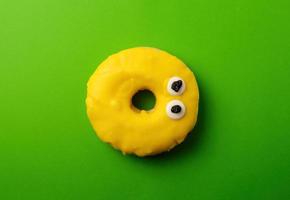 donut redondo de plátano amarillo sobre un fondo verde foto