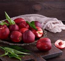 red ripe peaches nectarine in an iron plate photo