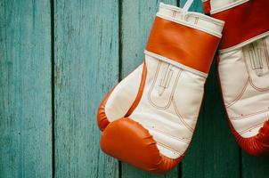 par de guantes de boxeo colgando de un gancho foto