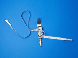 tenedor de hierro envuelto en una cinta métrica