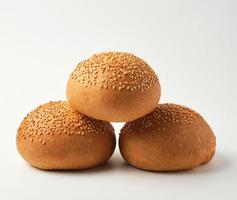 stack of baked whole round bun with sesame seeds photo