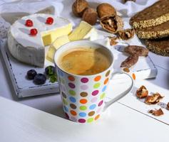 black coffee in a white ceramic mug in a multi-colored circle photo