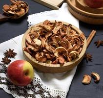 dried apple slices in a brown wooden bowl photo