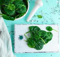 green spinach leaves on a white wooden board photo