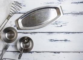 cocina objetos metálicos vacíos sobre un fondo blanco de madera foto