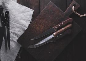 very old cutting brown wooden board and kitchen knives photo