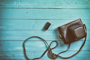 Vintage film camera in a leather case on a wooden camera photo