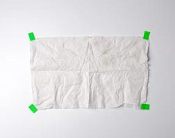 crumpled dirty white piece of paper towel glued with green paper velcro photo