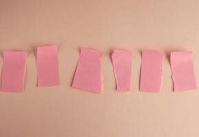 pegatinas de papel rosa pegadas en la pared y rotas por la mitad foto