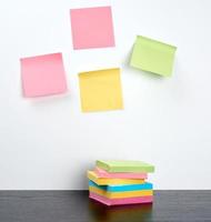 stack of multi-colored sticky stickers on a black wooden table photo