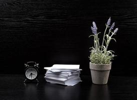 stack of white square note papers, a ceramic pot of lavender and an alarm clock photo