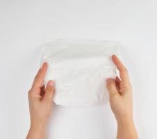 facial tissue in female hands over white background photo