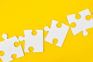 blank white big puzzles on yellow background photo