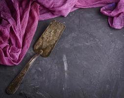 vintage iron spatula for dessert on a black surface photo