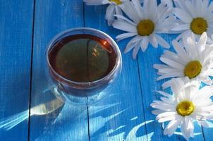 té de hierbas de manzanilla en una taza sobre una mesa azul foto
