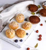 profiteroles with white cream and cupcakes with raisins photo