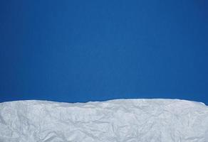 fondo azul con elementos de papel rasgado arrugado blanco foto