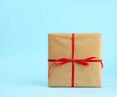 square box is packed in brown kraft paper and tied with a red thin silk ribbon photo