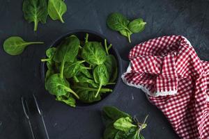 fresh green spinach in a round cast-iron frying pan photo