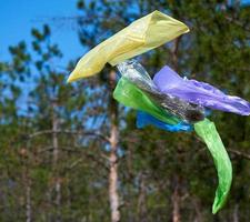 bolsas de plástico de basura vacías vuelan en el bosque foto