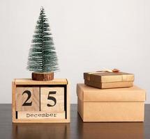 calendario retro de madera de bloques, árbol decorativo de navidad y cajas de cartón con regalos foto